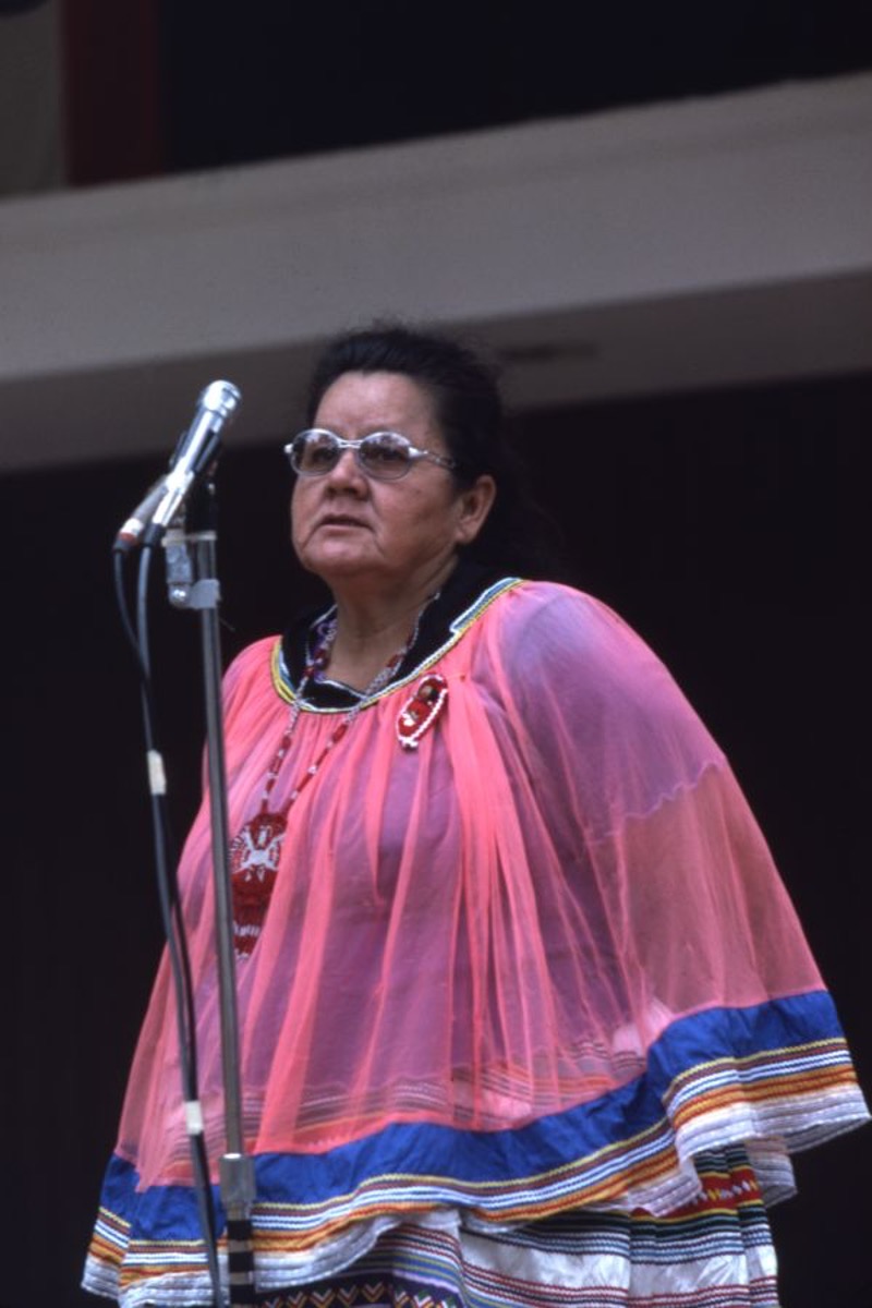 Betty Mae Tiger Jumper in a pink flowy top, behind a microphone